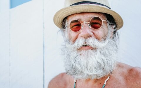 a man with a white beard and mustache wearing a hat