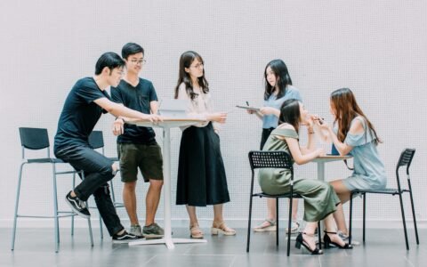 two men and four women meeting in office