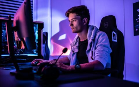 a man sitting in front of a computer monitor